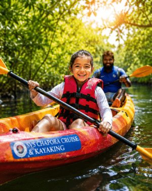 Tourists paddling colorful kayaks through dense green mangrove canals during a guided river cruise on Chapora River, North Goa.