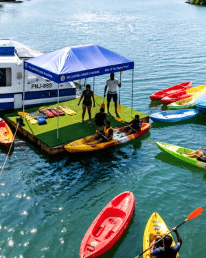 Young student kayakers raising their paddles in celebration during a guided eco kayak safari with SVS Chapora Cruise
